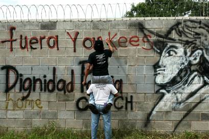 Oct. 6, 2008: Demonstrators write "Out Yankees" on a wall outside the U.S. Palmerola military base in Honduras during a protest against American military presence in Latin America. Photo: Edgard Garrido / Reuters file 