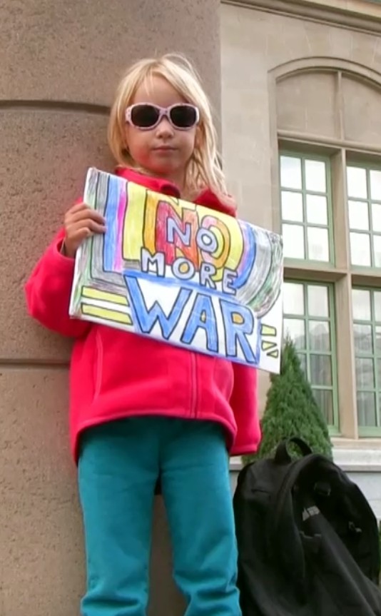 September 12, 2013: The youngest member of an information picket outside the Fort Garry Hotel in Winnipeg, denouncing Lloyd Axworthy's call for war with Syria. Photo: Paul S. Graham 